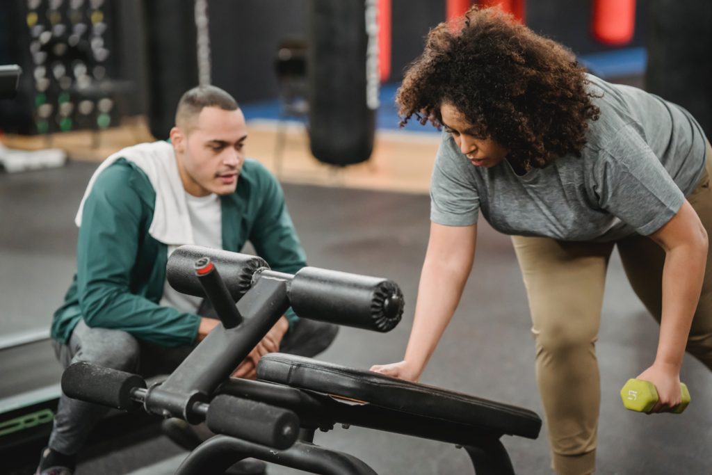 Fitness instructor helping client
